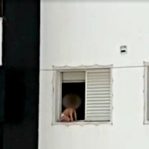 Criança é flagrada brincando na janela de prédio